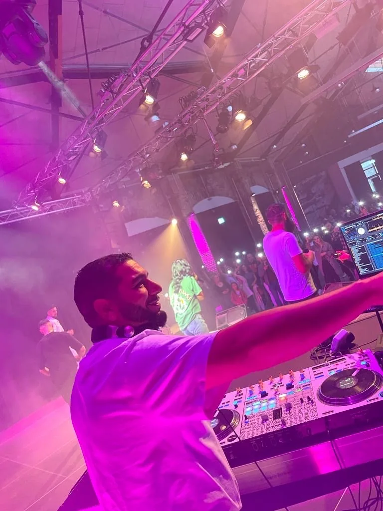 DJ RE-SOUND an den Decks bei einem Event mit violettem Bühnenlicht